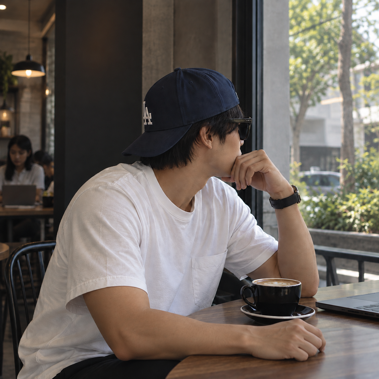 Kato Tam sitting in a coffee shop with a laptop and coffee